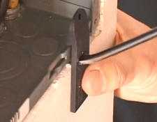 Next insert the modified screwdriver through the hole and between the drywall under the knockout to be removed.